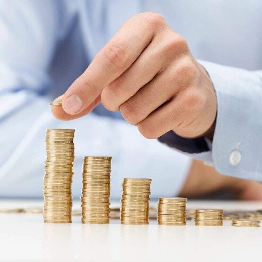 A person is stacking coins on top of each other.