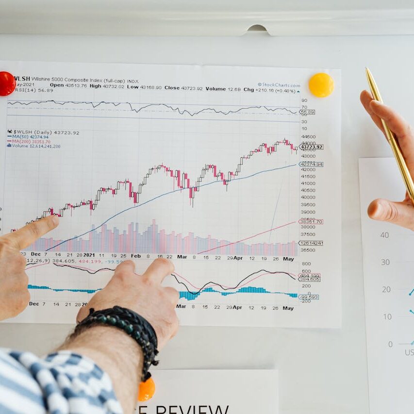 A person pointing to a chart on the wall